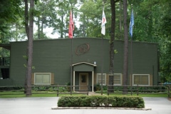 A large green building with flags and trees in front of it.38