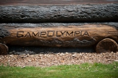 A log with the words Camp Olympia carved into the side.