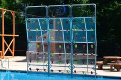 A swimming pool with a climbing wall next to it.